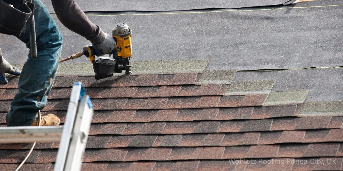 Roofer repairing shingles on a storm damaged roof in Ponca City